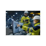 Image of Two People in Safety Vests and Hard Hats looking at a computer