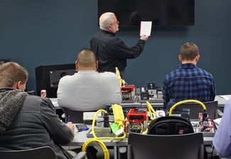 Image of a man teaching a class full of people