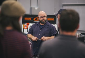 Image of man wearing safety glasses teaching a group of people