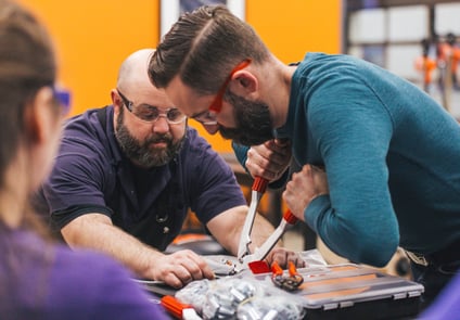 Image of two men working together on repairs
