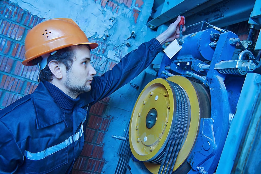 Worker Making Adjustments to Elevator Image