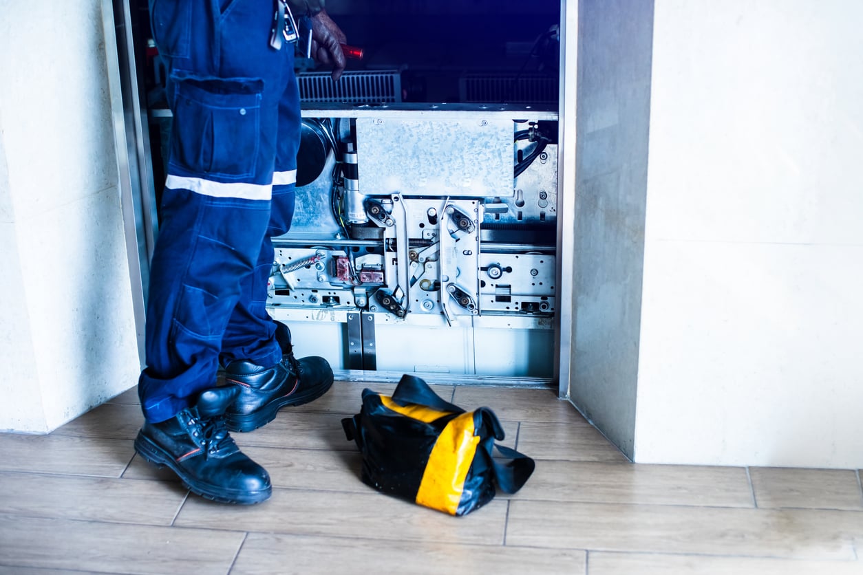 An elevator technician performing maintenance or repairs